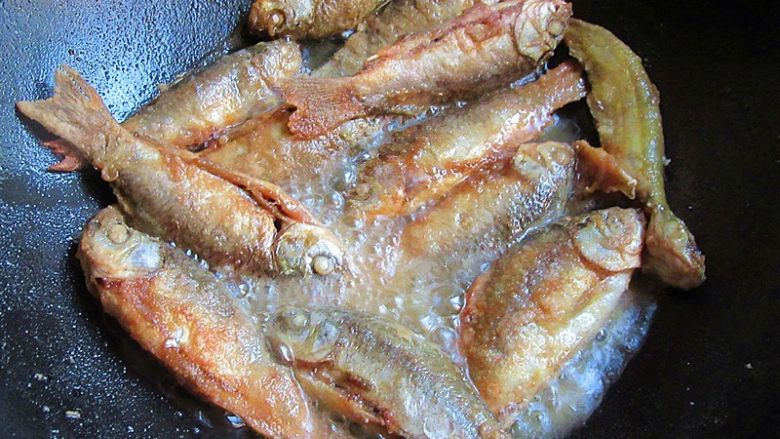 家乡特色美食——杂鱼炖小豆饼,热锅注入油烧至7成热,将过拿起摇晃一下,放入小鱼慢火煎