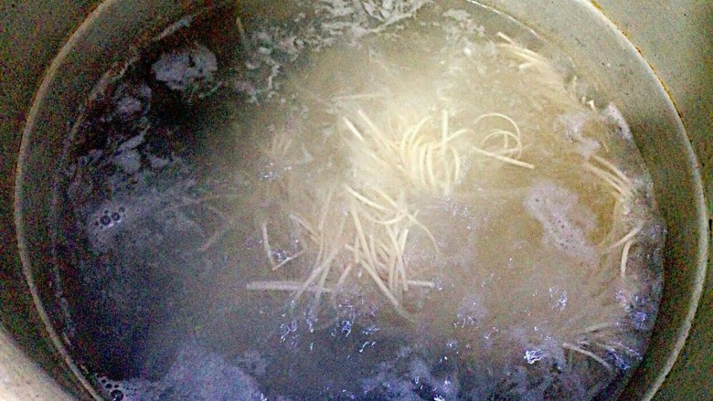 极简葱油面,上锅烧开水,放入一把面条,用筷子搅动,以防面条粘在一起