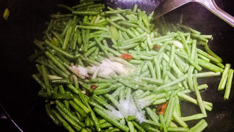 炒豆角,加入盐、鸡精、胡椒粉、加入适量的水以免锅太干，继续翻炒1分钟