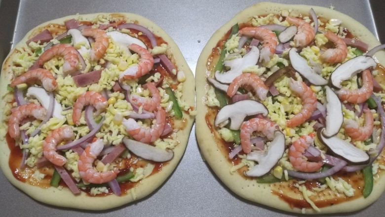 鲜虾火腿披萨,食材和芝士碎交错这撒在饼皮上,最后摆上剥壳的虾仁。