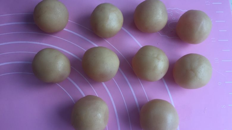 莲蓉蛋黄月饼(50克),然后莲蓉捏成小圆皮包住蛋黄。搓圆备用。