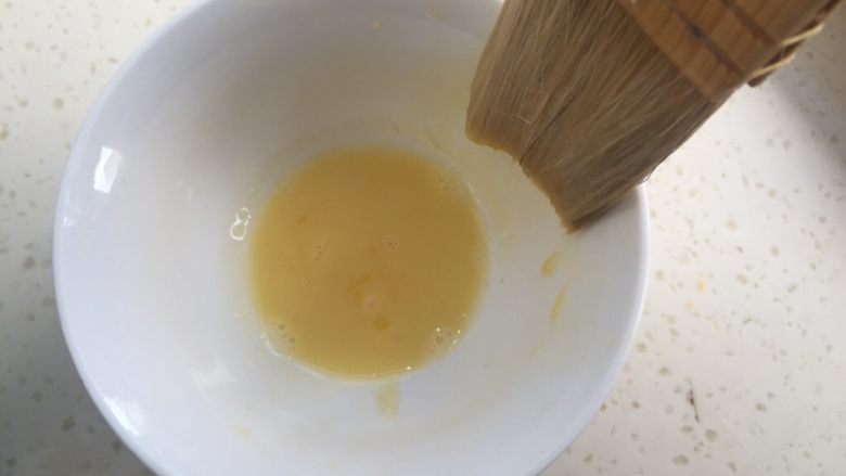 莲蓉蛋黄月饼(50克),准备蛋黄液。一个蛋黄加入10克水调匀。
