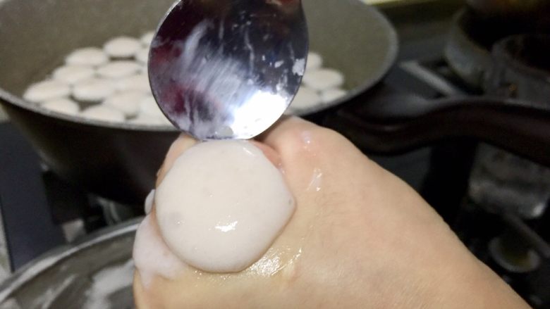 三色清水鱼圆,准备一锅水,点点热就可以下鱼圆了,下面用最小的火煮着,千万不可以用沸水下鱼圆,鱼圆会散掉,就这样温水满满的养着。手掌里窝少许鱼圆,用虎口挤出鱼圆,用勺子刮下入水。勺子每次用完都放在清水里涮下,这样下次挤鱼圆不会粘在勺子上。