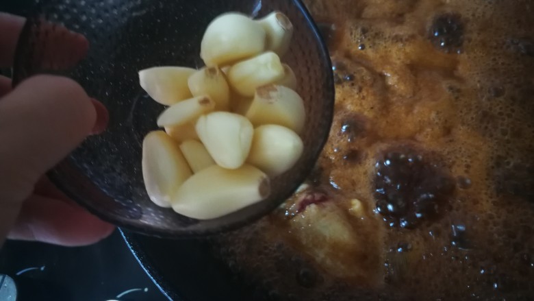 红烧鸡翅,加入蒜头,中火炖煮。