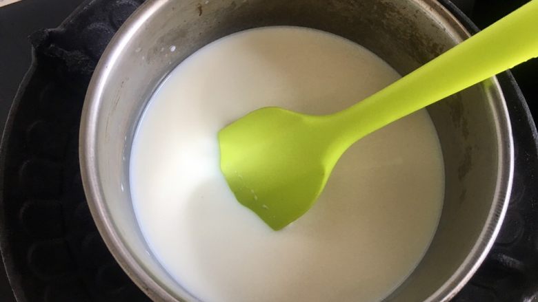 自制炼乳(奶粉版),倒入奶锅,小火加热,要用刮刀不停的超底搅拌,防止糊底。