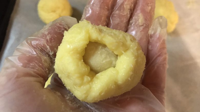 💋流心榴莲月饼🍥,把流心馅从冷冻箱里拿出来,同样分成24等份,每份约5-7克。再用榴莲芝士馅把流心馅包入,一定要把口给收紧,以免流馅。做好后重新盖上保鲜膜放入冰箱冷藏至少一个小时,再进行下一步操作。
P.S 这个过程一定要快,不然这馅在这么炎热的天气下很容易就融化了。如果手慢的亲们建议在空调房里操作,减慢融化的速度。