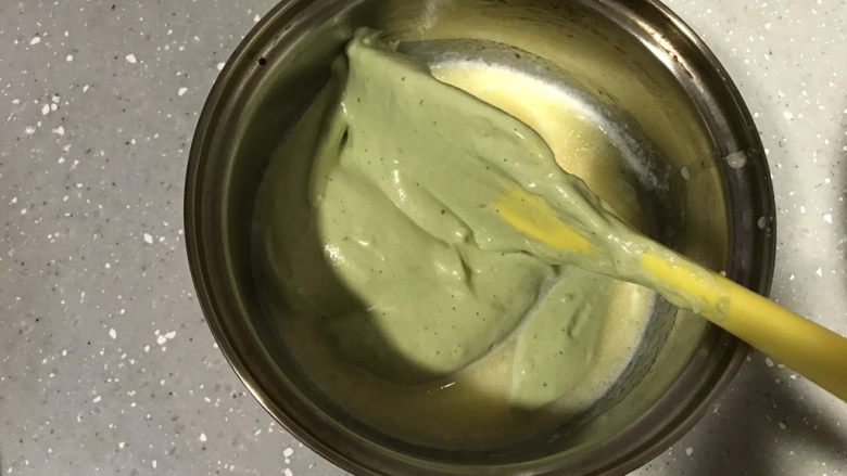 抹茶杯子蛋糕,取一小勺蛋糕糊到黄油和牛奶的混合物中,翻拌均匀。