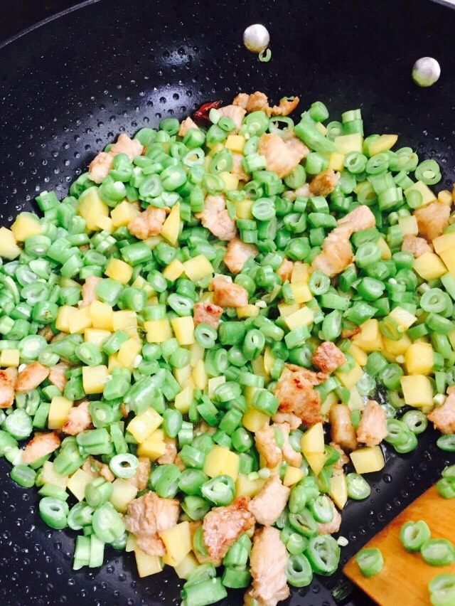 扁豆土豆猪肉卤拌米饭,倒入<a style='color:red;display:inline-block;' href='/shicai/ 68'>扁豆</a>丁翻炒，然后加入水闷煮。照片忘记拍了，煮熟就可以。
