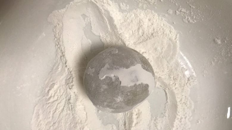 广式五仁月饼,取一个面团放在手粉里滚一下,用手搓掉多余的粉