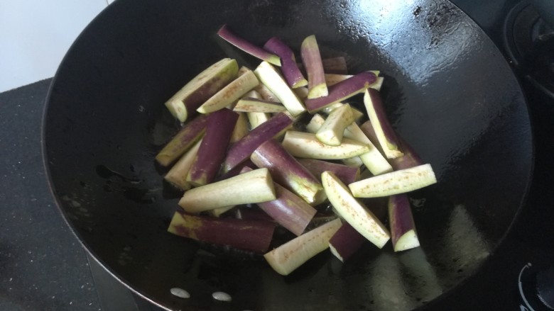 茄子豆角,倒入茄子快速翻炒。