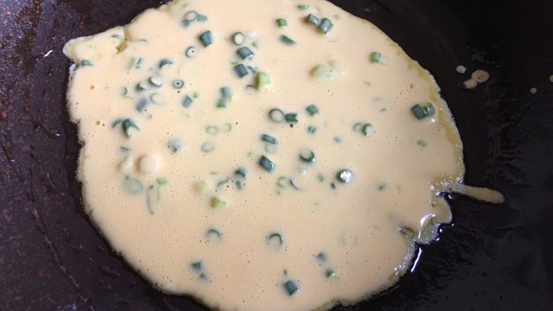 葱花鸡蛋饼,加热平底锅,锅中抹上少许油转小火,倒入两大勺面糊,用勺子底部将面糊摊平