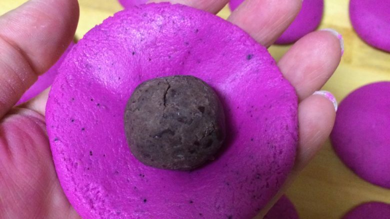 水果汁糯米饼,取一个小剂子,用手轻轻捏圆压扁成面皮,中间放入豆沙馅