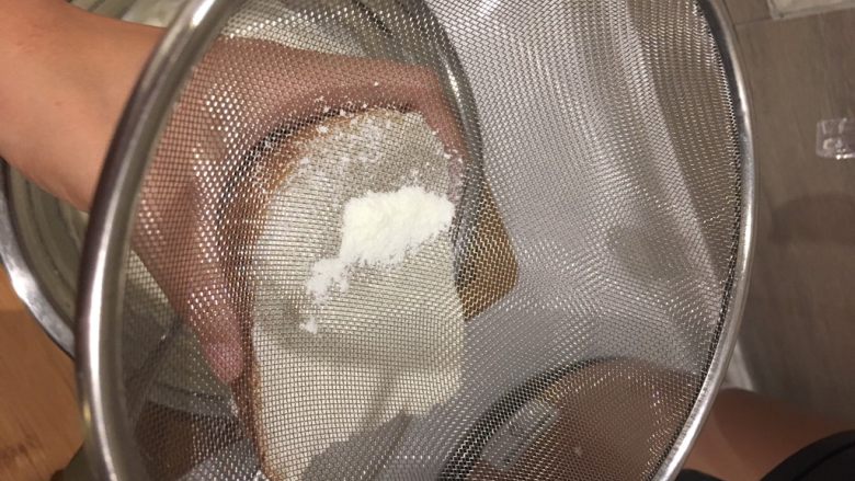 奶酪餐包,用筛子过滤奶粉,均匀撒在涂满奶酪的面包上