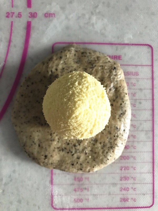 伯爵红茶奶酥面包,松弛面团期间将奶酥馅均匀分为6份,揉圆备用。取出松弛好的面团擀成圆形,包入奶酥馅,捏紧收口后,收口朝下放置。加盖保鲜膜松弛10分钟。