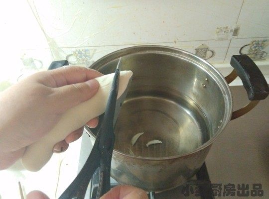 双色剪刀面,煮锅中加水,不要等水煮开,用剪刀转圈将面直接剪入锅中。