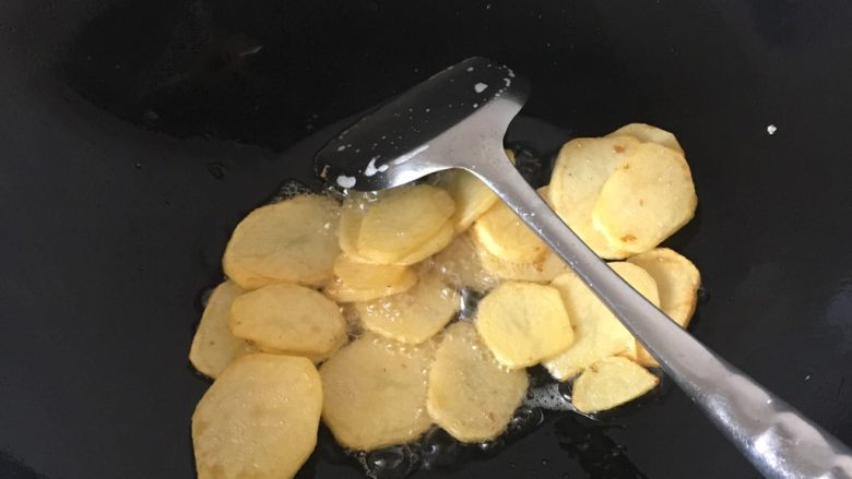 麻辣香锅,锅里下油烧热,把土豆片放进去煎,煎到土豆表面金黄就盛起来。