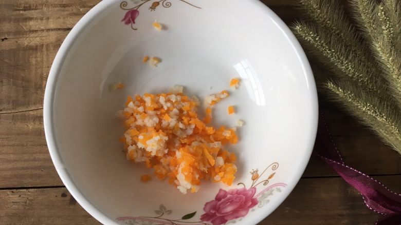 蒸三文鱼鸡蛋蔬菜小方,取一个大碗,淮山和胡萝卜切成细碎的丁状放到碗里,一岁以内的宝宝吃,也可以将它们打成泥更有利于宝宝吞咽噢~