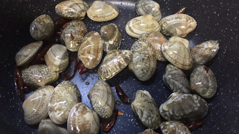 辣炒蚬子,加入蚬子翻炒下,再开中火炒制。(担心大家蚬子擦的不够干被油溅到,所以倒蚬子前先关火)