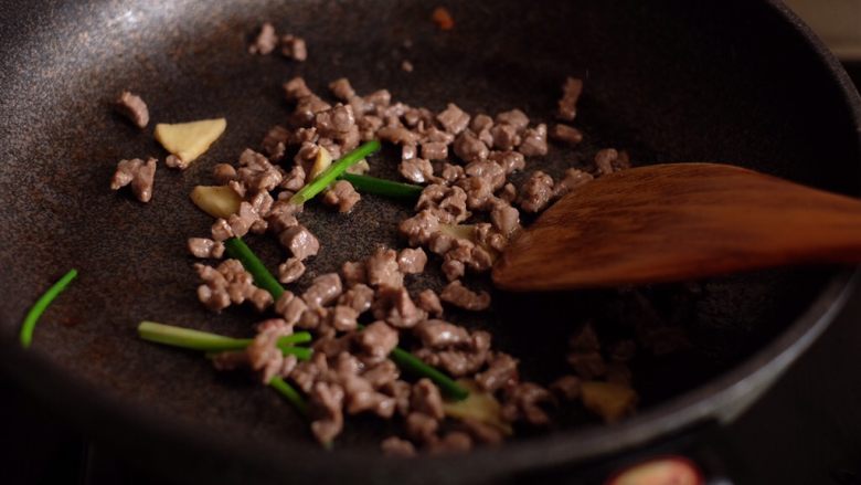 番茄牛肉拌面,待牛肉变色后加入葱段和姜片,翻炒至出香味
