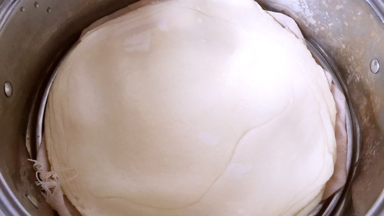 水单饼(烫面法、附卷饼方法),把擀好的面皮放在蒸笼上(放之前在底部刷一层油,防止粘在笼布上),冷水上锅蒸15min