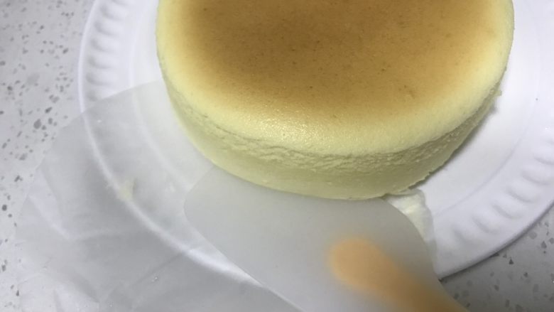轻乳酪蛋糕,轻轻抖出蛋糕在盘子里,取出底部油纸,也可以不取。