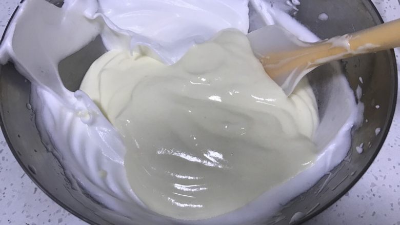 轻乳酪蛋糕,将蛋白霜挖取三分之一到奶酪糊中翻拌均匀,再将拌好的面糊倒入蛋白盆中。