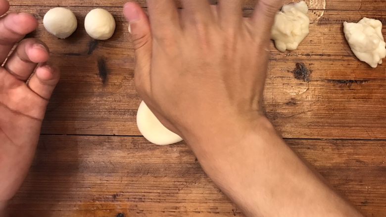 超详细的经典蛋黄酥,⏸将小面团开口朝上,放置在操作面板上,用手轻轻按压,压成饼式。放入保鲜袋中,静置15min。