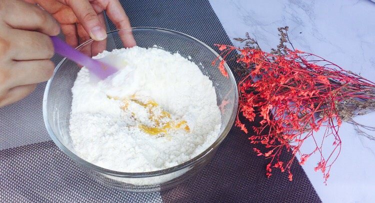 七夕南瓜玫瑰馒头,所有材料混合好后,进行搅拌,拌成絮状,可以让面粉更好吸收南瓜泥的水分!