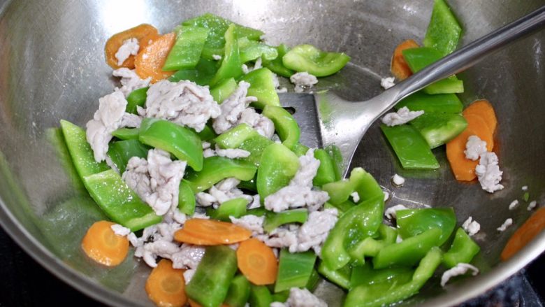 青椒炒肉,再放入肉丝,最后再加入半勺盐,翻炒均匀即可