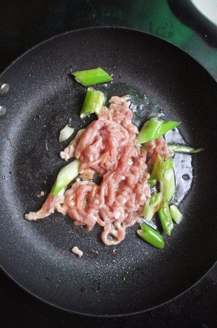 水烙馍卷菜,锅中放油,油热之后放入花椒葱,慢慢炸香,放入肉丝翻炒。