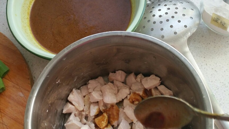 咖喱鸡块饭,将咖喱水浇到鸡肉上,放入少量淀粉,拌匀。