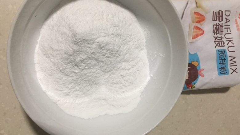 芒果雪媚娘,190克雪媚娘预拌粉倒入碗中,留下10克左右粉包皮用。