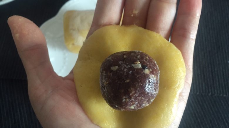 韩式南瓜🎃小月饼,在冷冻的南瓜圆柱面团上取21.5克面团用手压扁,中心略厚,边缘薄,饼皮大小以图中为宜