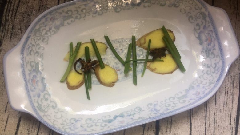 剁椒鱼头**凉面,在盘底把姜、葱、八角摆上