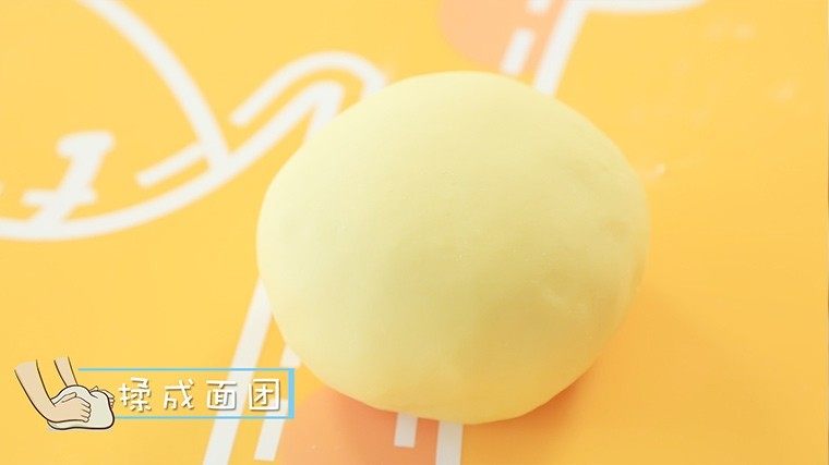 橙汁磨牙棒,面絮倒在面垫上,揉成光滑不粘手的面团。