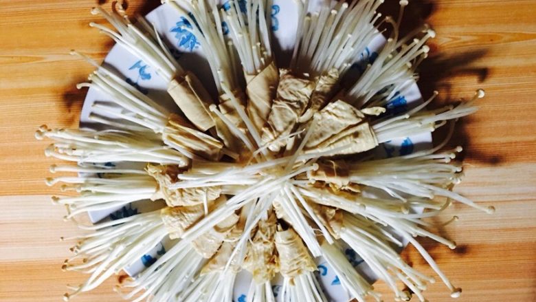 蒜香豆皮金针菇,如图:取一张豆皮卷上少许金针菇码放在盘子里
