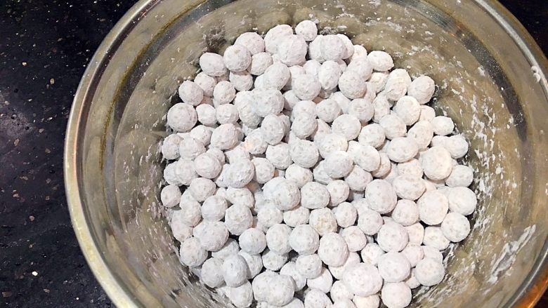 珍珠丸子,盆里放入木薯粉(2),搓好的珍珠丸子放入,滚动盆子让珍珠丸子沾满木薯粉,预防丸子粘在一起