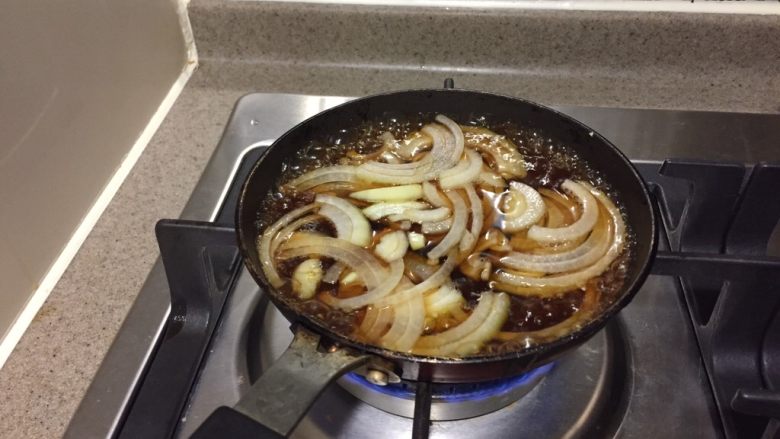 冻豆腐鸡蛋丼,煮开的酱汁加入洋葱,煮开。