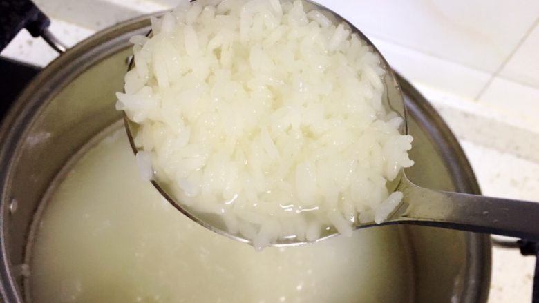 紫豇豆焖饭,将大米煮至表面熟透,里面有白芯时关火。