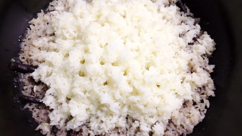 紫豇豆焖饭,盖上锅盖,用均匀的中小火(不能用小火,这样就只能中间受热)加热焖饭。这个过程必须注意火候,是焖饭成功关键,不好火太大焖饭会烧焦。听到有锅巴开始滋滋的声音时迅速关火,再焖两三分钟即可。