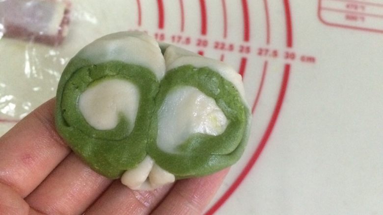 炫彩椰蓉开口酥,取一份松弛好酥皮,用手指中间压下,两边向中间对折。