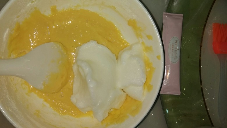 电饭煲版蛋糕,6加入1/3的蛋白液到蛋黄盆用勺子上下翻动拌匀,拌好后直接倒入蛋白盆里面一起上下翻动拌匀
