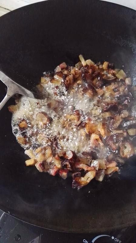 侗家社饭的做法,腊肉里的瘦肉挑出来,以免炒久变糊。然后放少许菜籽油,等油熬好,没有气泡后,把肥腊肉和腊肠一起炒,等炒出油来,锅里冒出很多油的泡沫后,再放下瘦