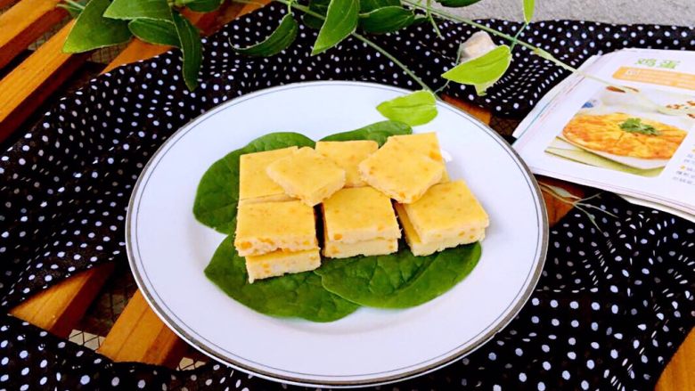 蒸三文鱼鸡蛋蔬菜小方,大火大概10-12分钟即可熟透,取出盘子放凉倒扣一下脱模切成大小均匀的块状。如果不好脱模,可以借助小铲子来脱模。