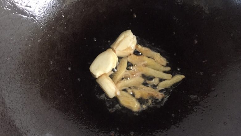 油焖大虾,把油倒出,锅中留底油,放入蒜瓣、姜片爆香。