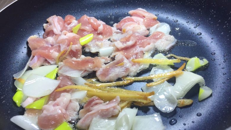 豆角焖面,锅里倒油炒香葱姜，倒入肉片。