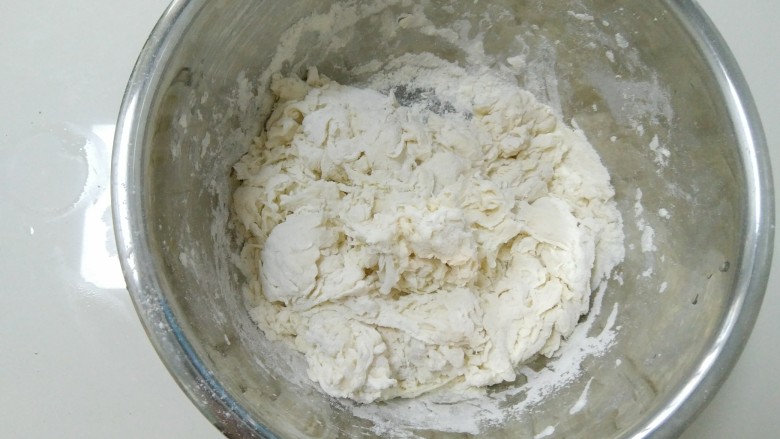 家常韭菜鸡蛋水饺(付饺子皮详细教程),倒入面粉里,拌成絮状或者面片状。