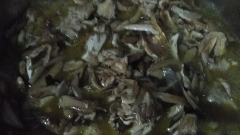 超下饭拌面百搭开胃料——云南炸菌子(油鸡枞),放菌伞炸,约一个小时后水分差不多干,改小火炸至菌子都变黑褐色,放入干辣椒和蒜,翻拌炸香,约五分钟后即可关火。