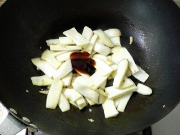 蚝油杏鲍菇,5. 加入一大勺蚝油翻炒上色后,加两汤匙水焖煮至杏鲍菇变软