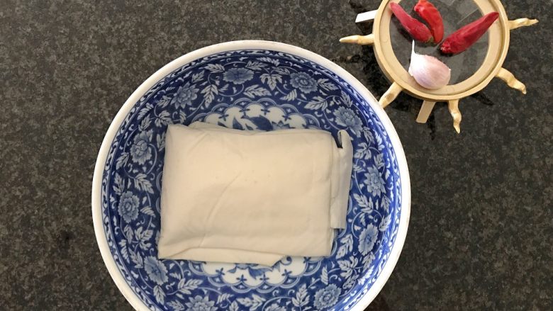 雪菜毛豆炒厚百叶,首先我们将厚百叶泡在清水里浸泡5分钟,去一下它的豆腥味